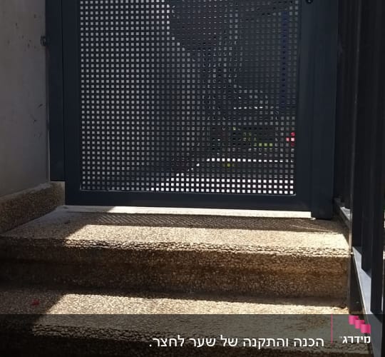 שער מתכת עם חורים מרובעים על מדרגות